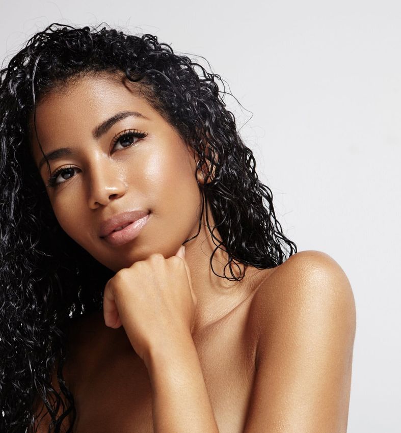 Woman with curly hair and radiant skin.