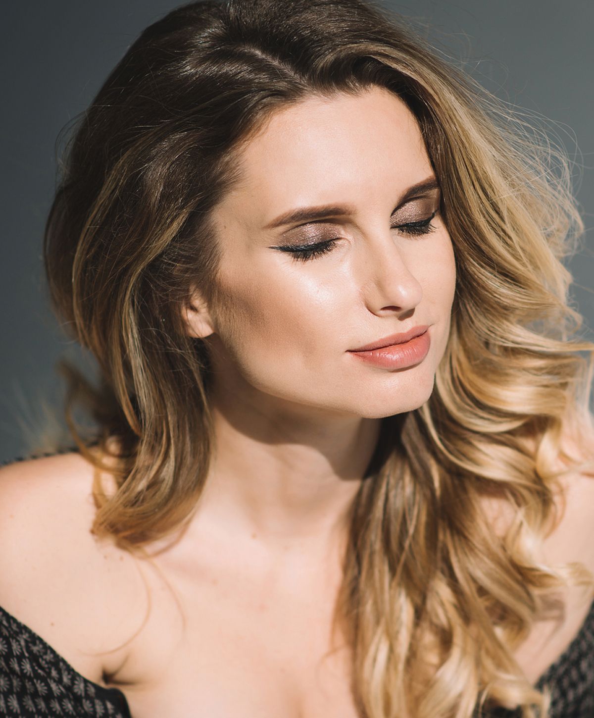 Woman with closed eyes and soft, wavy hair.