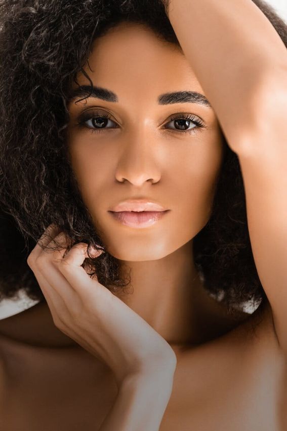 Woman with curly hair and natural makeup.