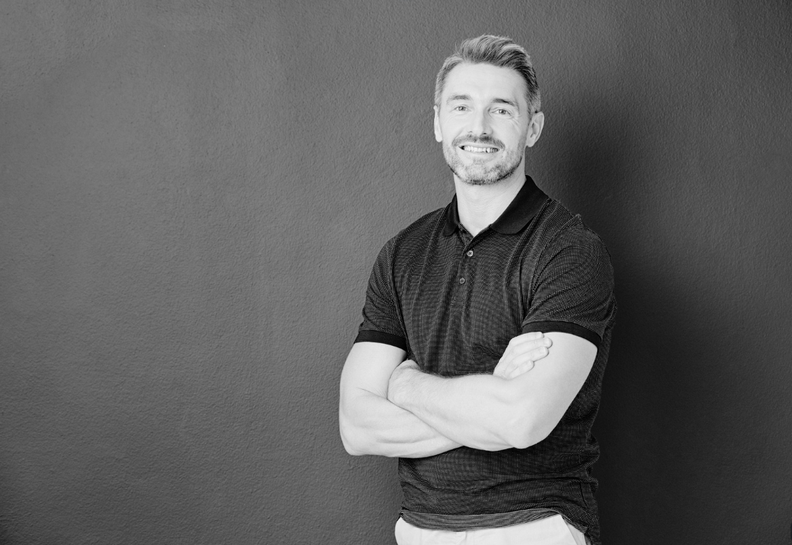 Man showing muscular back against dark background