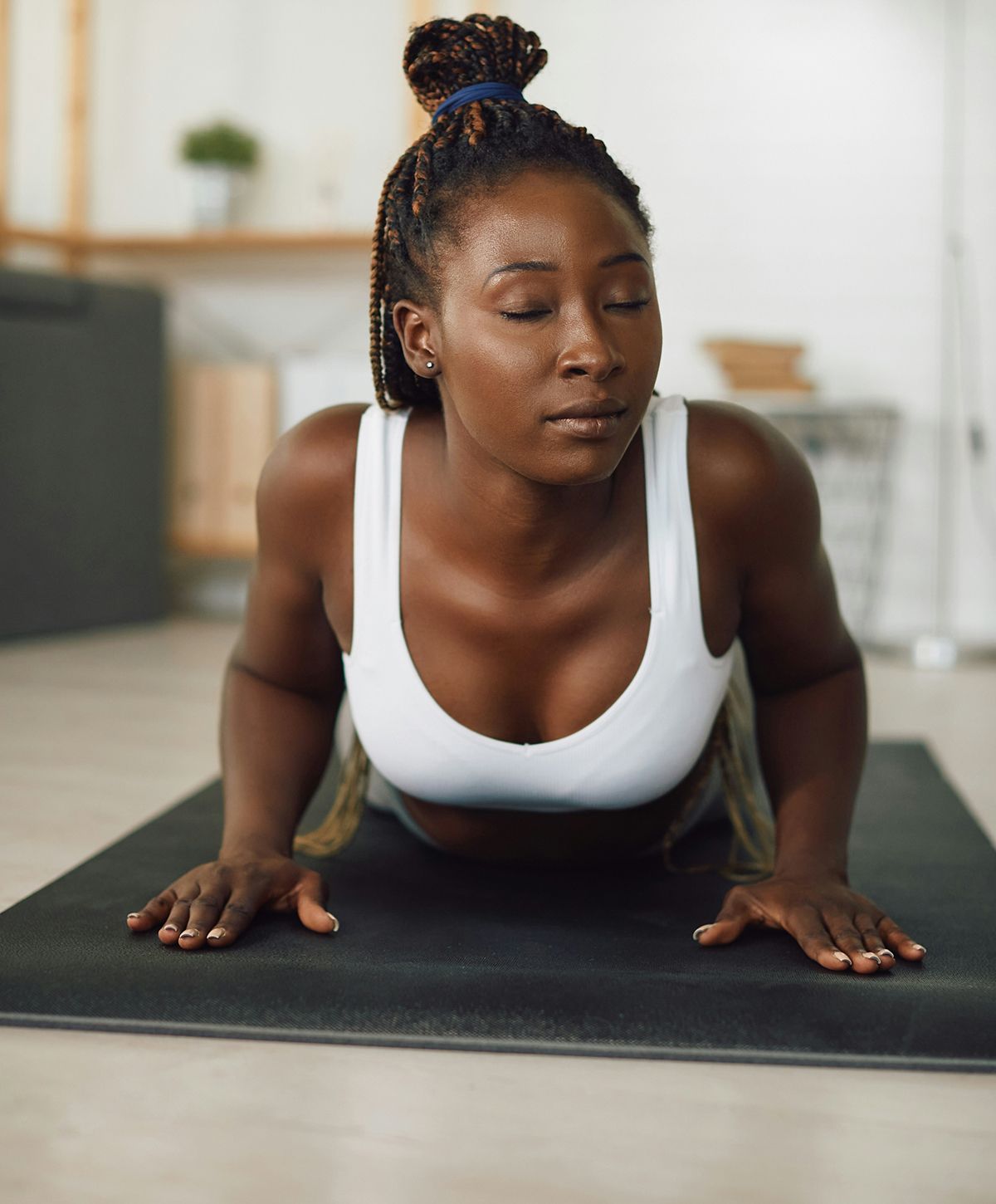 Woman practicing yoga on a mat indoors.