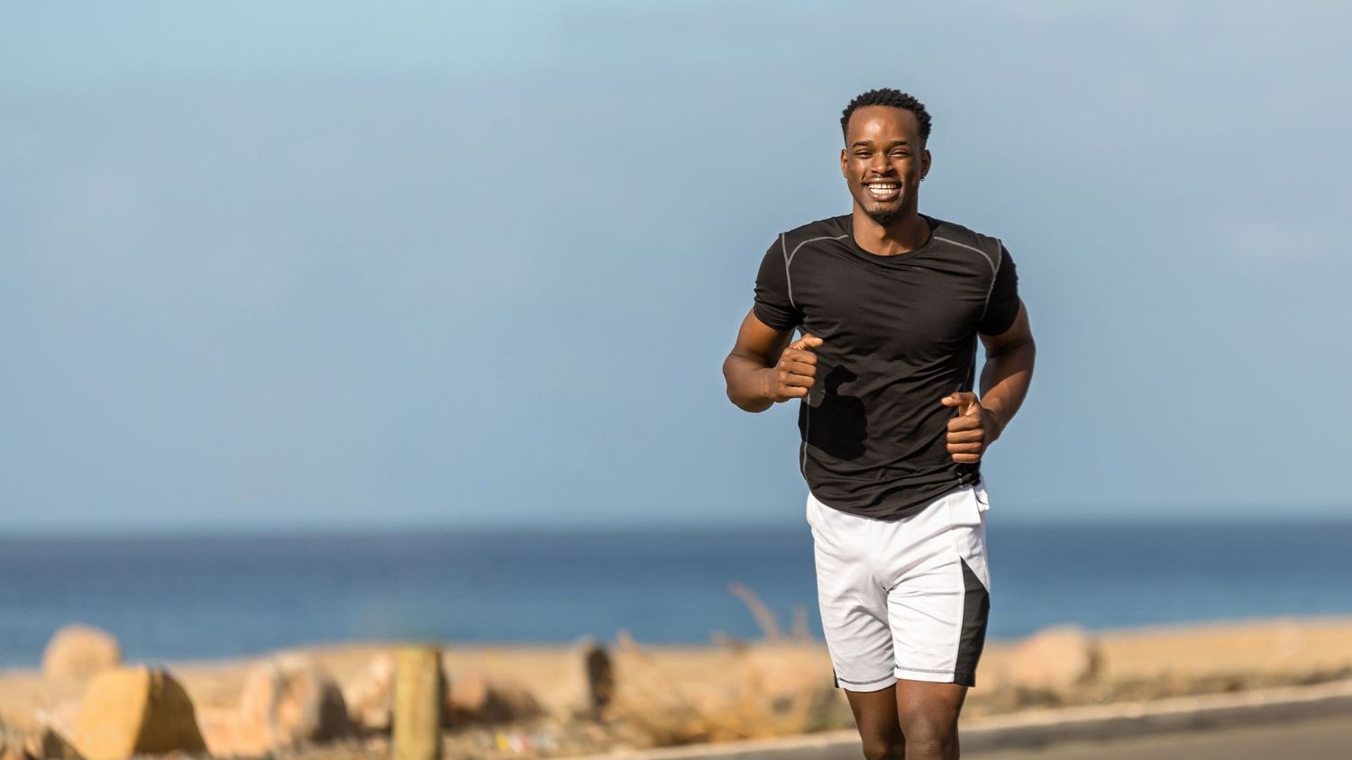 Man posing in natural light, showing physique.