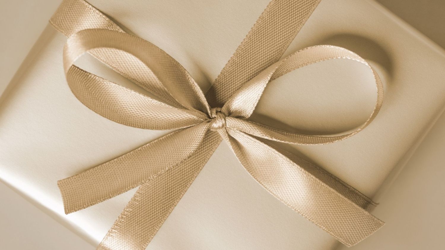 Person holding a small black gift box.