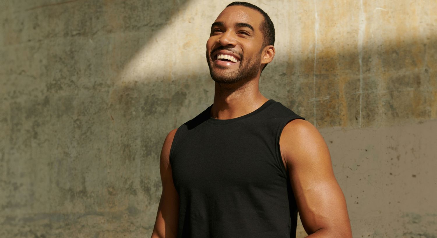 Smiling man in a black tank top.
