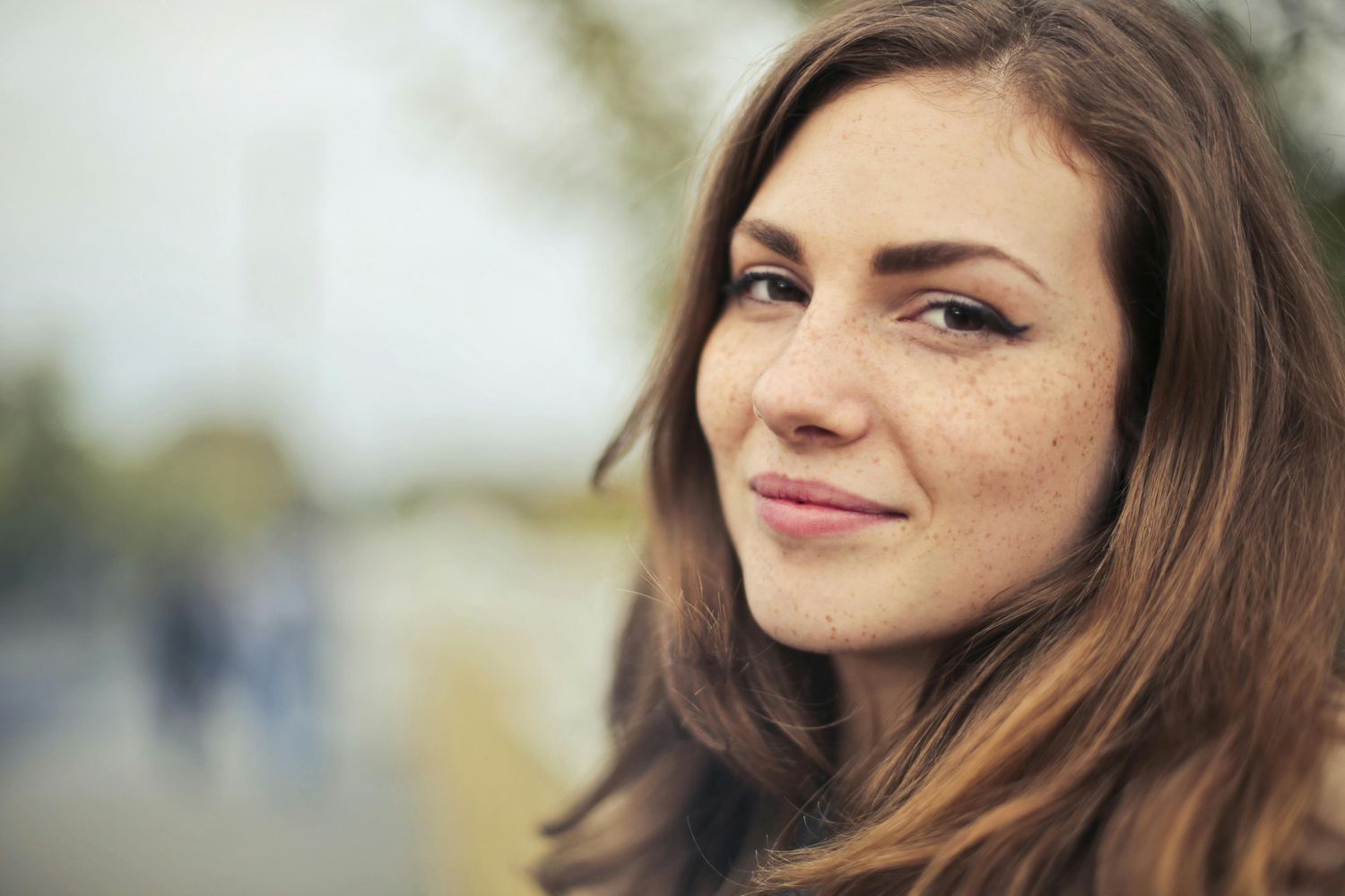 Smiling woman with long dark hair indoors.